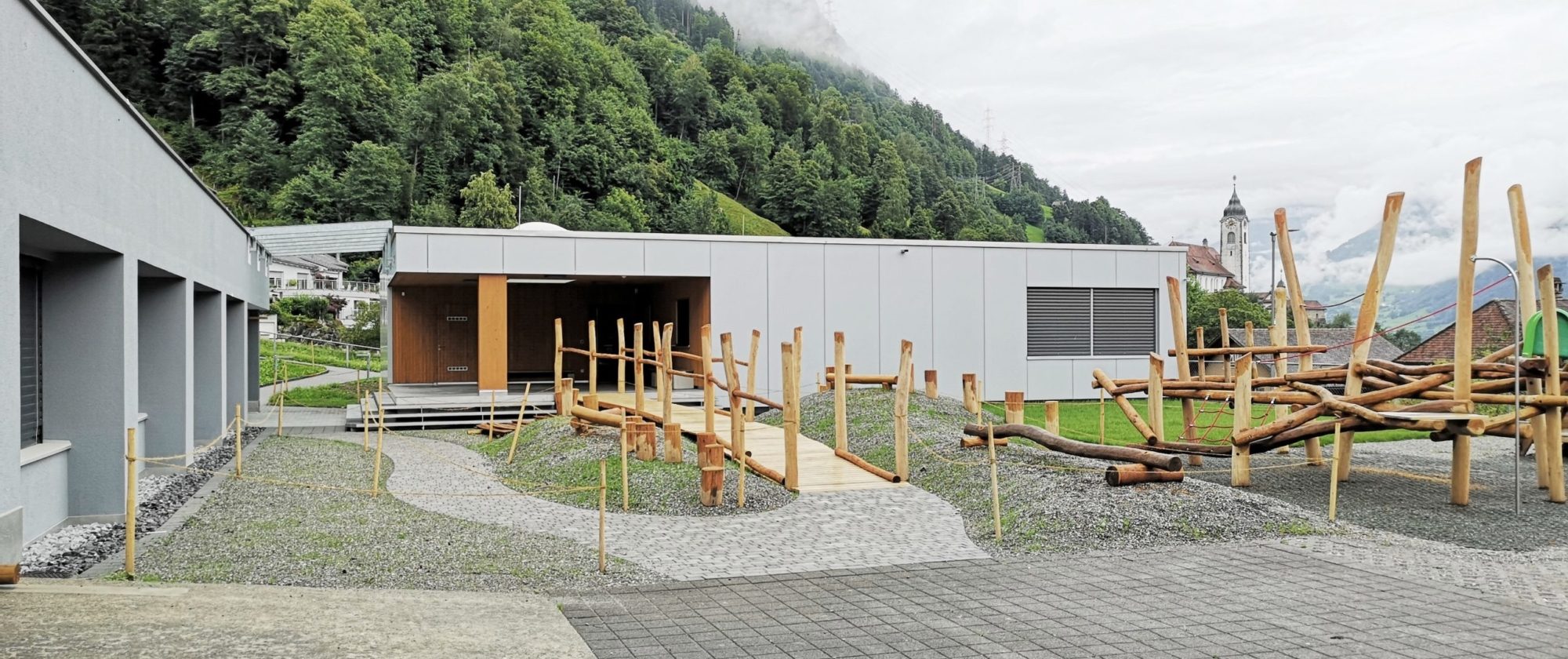 Aussenansicht des Neubaus Kindergarten Gehren mit Spielplatz im Vordergrund